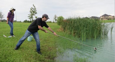 Two CSI program participants collect lake water samples
