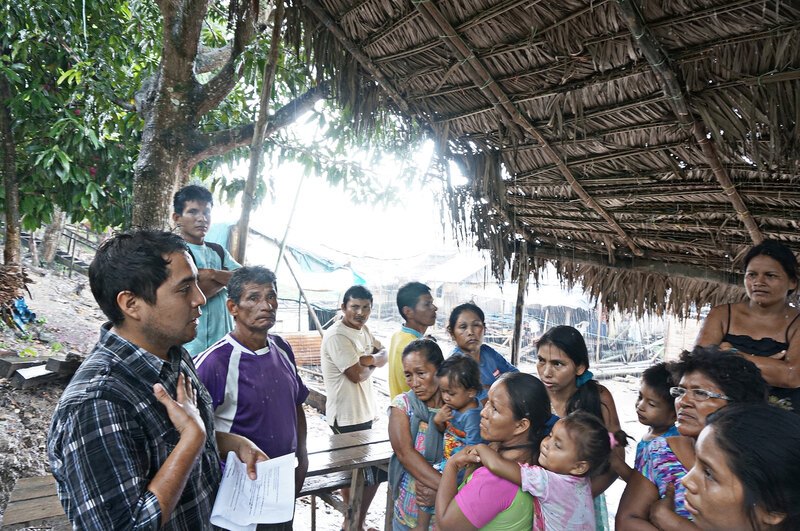 An image of Coco Alarcón leading a discussion with group of Peruvian people