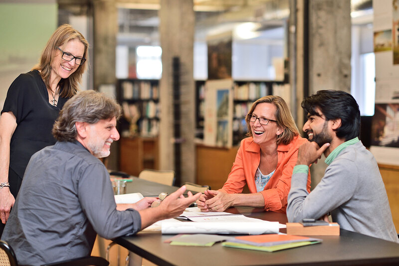 An image of four Mithun employees having a conversation at a table