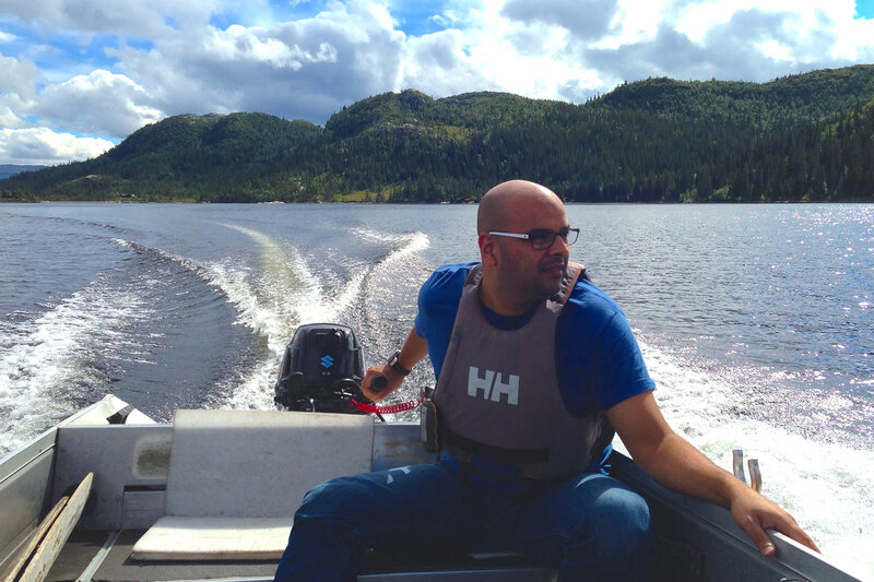 An image of Amir Gohar steering a motorboat