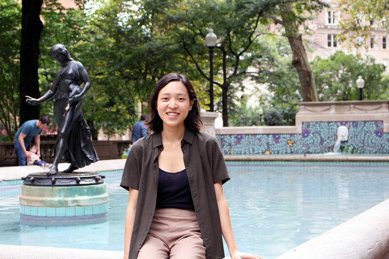 Christine Chung sits on the edge of a fountain