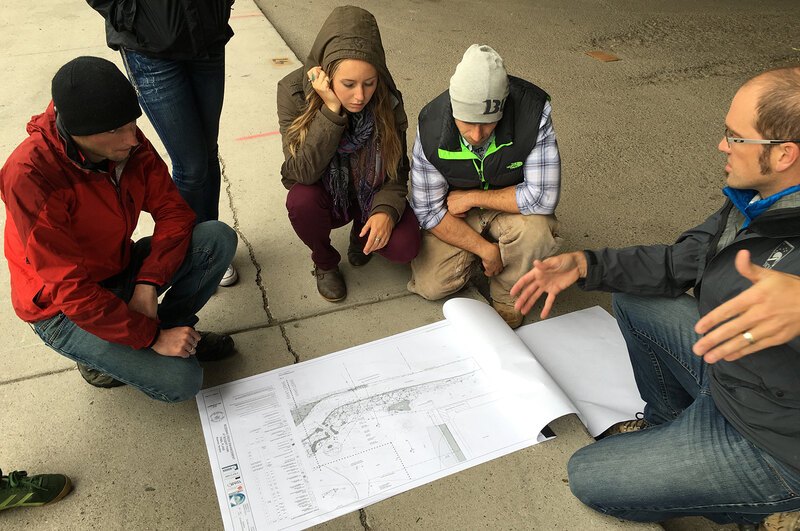 Students gather around a siteplan