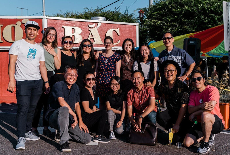 A group of students and Jeff Hou pose for a picture at an unknown outdoor event