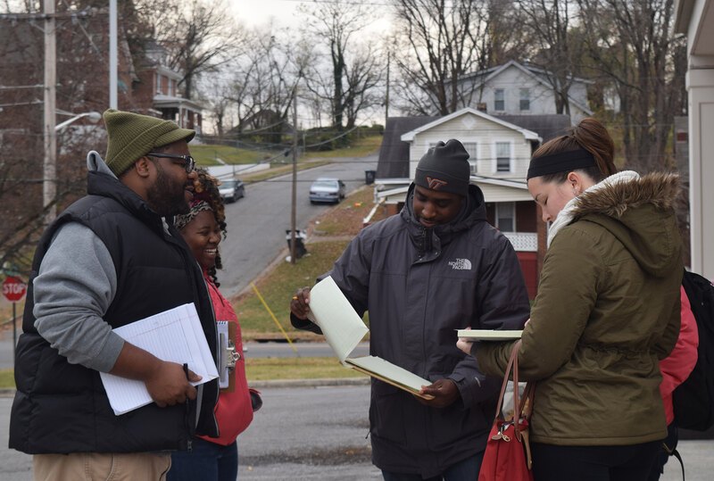 CL Bohannon speaks with a group of 3 Virginia Tech students engaging in fieldwork in their community