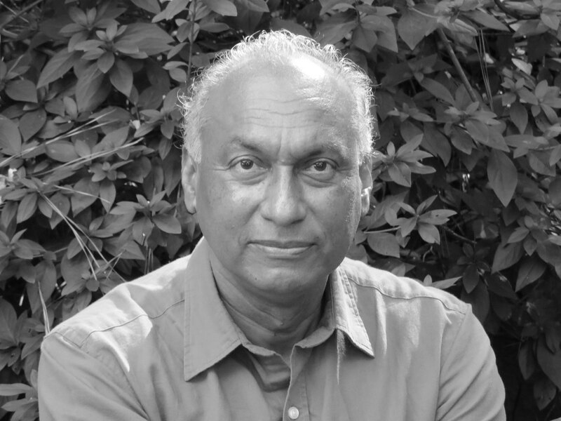 (black and white) Fernando Magallanes poses in front of greenery