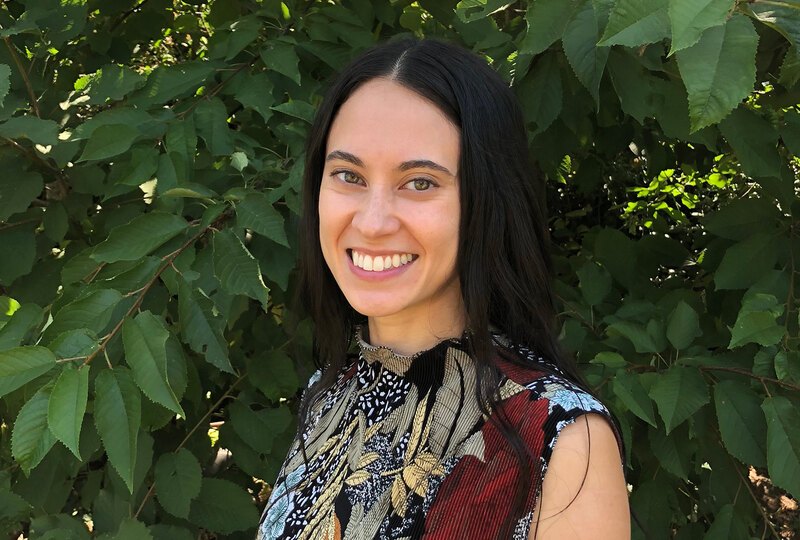 Image of Elizabeth Chong Baskerville smiling in front of greenery