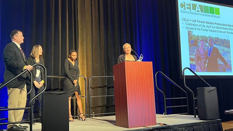 June Martin stands behind a podium and gives remarks