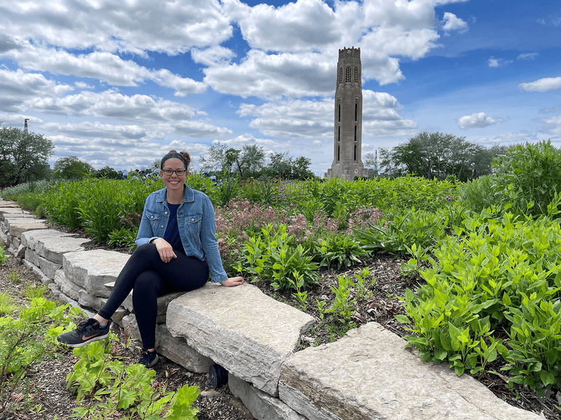 Isabella Shehab sits on a stone wall in Detroit.