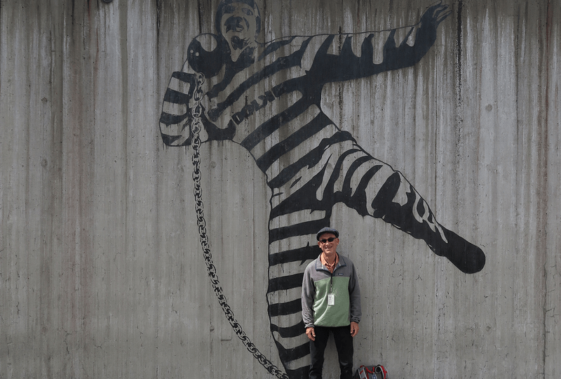 Daniel Winterbottom stands in front of a mural at a prison in Norway.