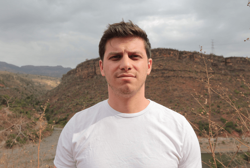 Robert Levinthal stands in front of a hill. 