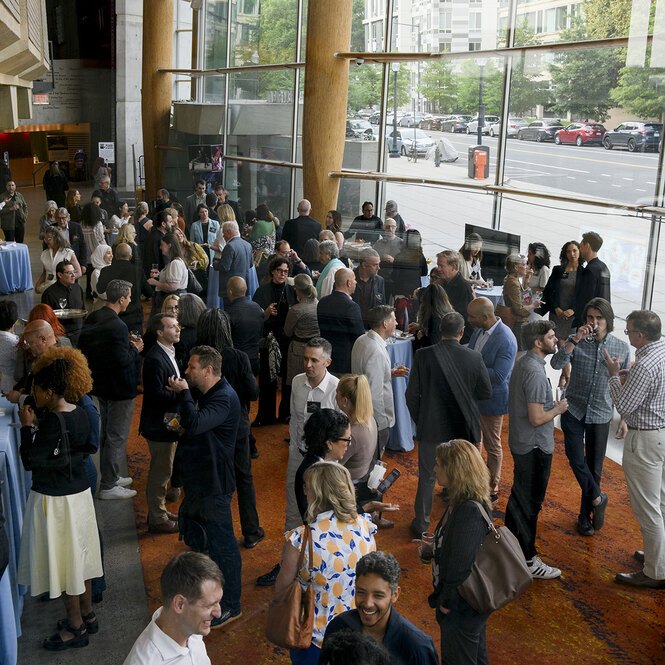 Looking down on a crowd of reception attendees in the glass-sided lobby of the theater