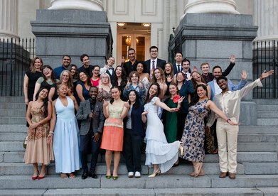 32 of the 2025 Olmsted Scholars do a silly pose on the steps of Gallier Hall before LAF's 40th Annual Benefit
