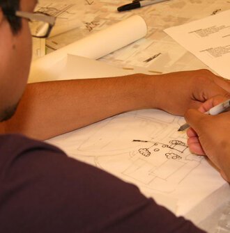 A landscape architecture student draws on trace paper