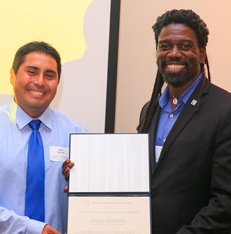 A scholarship winner with EDSA's Kona Gray holding a certificate
