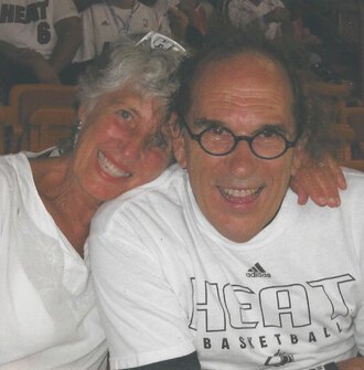 Jeanne and Joe Lalli smiling in the bleachers at a Miami Heat game