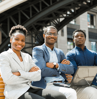 3 Black students in business attire look confident sitting on a bench