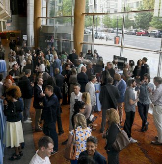 Looking down on a crowd of reception attendees in the glass-sided lobby of the theater