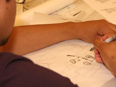 A landscape architecture student draws on trace paper