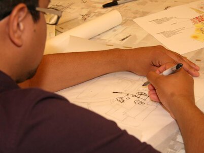 A landscape architecture student draws on trace paper