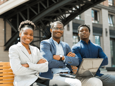 3 Black students in business attire look confident sitting on a bench