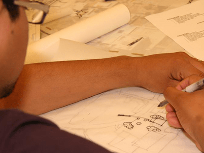A student traces a design on paper.