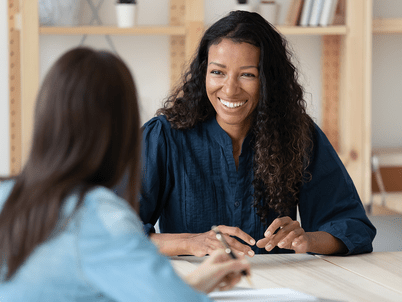 A smiling professional engaged in conversation with a student
