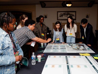 An instructor pointing out specifics on a model to a table of students