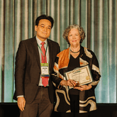 Jun-Hyun presents the 2024 Forster Ndubisi Professional Service Award to Elen Deming