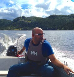 An image of Amir Gohar steering a motorboat