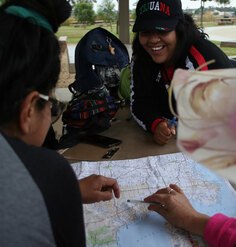 Hispanic/Latino youth gather around a map at a picnic table