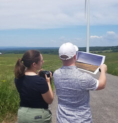 Meaghan Keefe and Aidan Ackerman compare a before photo to the site at the time of evaluation