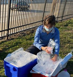 A woman packs data samples into a cooler along the side of the 1-95 corridor