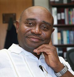 Forster Ndubisi sitting in an office with a bookshelf in the background