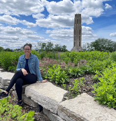 Isabella Shehab sits on a stone wall in Detroit.