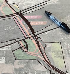 A marker lays on top of plans for a new bridge over the Mississippi River. 