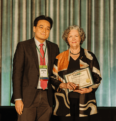 Jun-Hyun presents the 2024 Forster Ndubisi Professional Service Award to Elen Deming